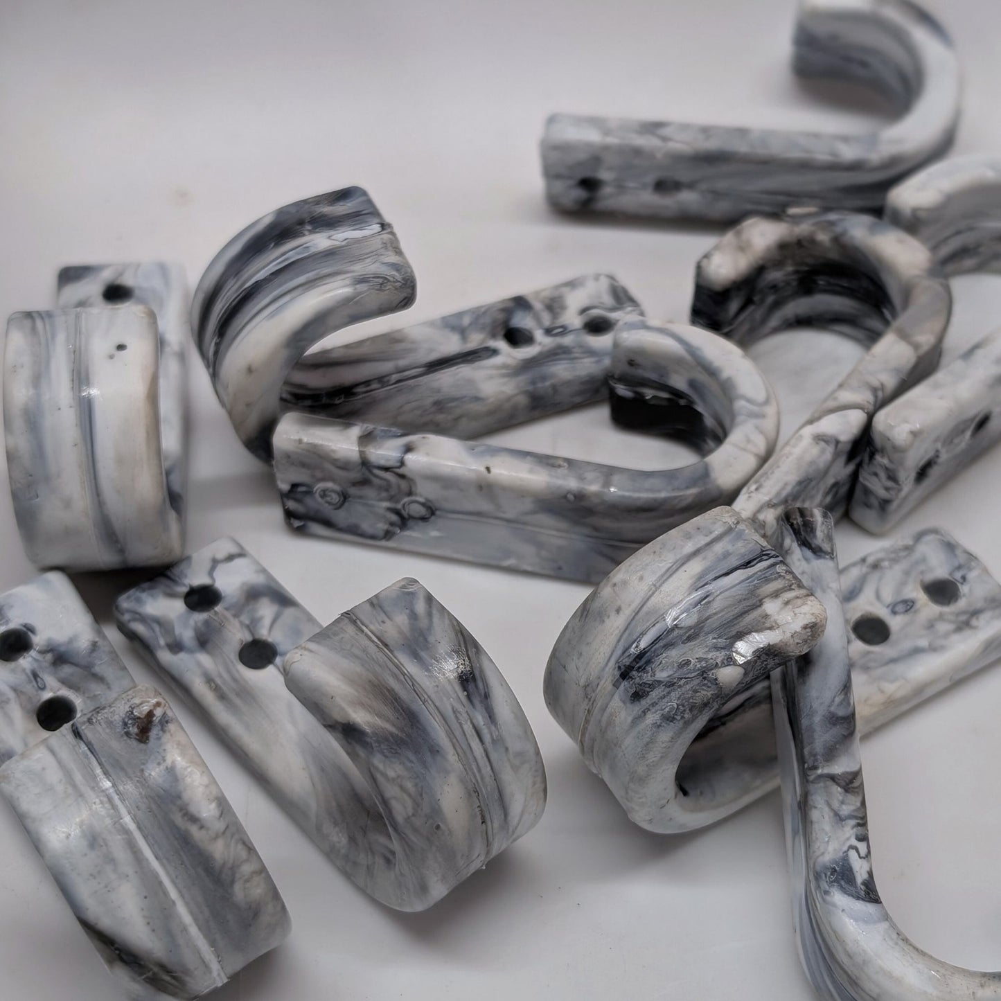 Marble-patterned wall hooks on a white background