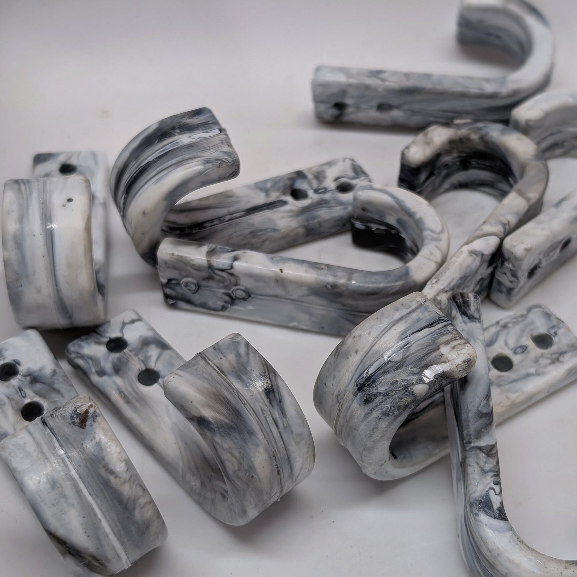 Marble-patterned wall hooks on a white background