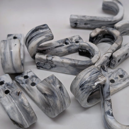 Marble-patterned wall hooks on a white background