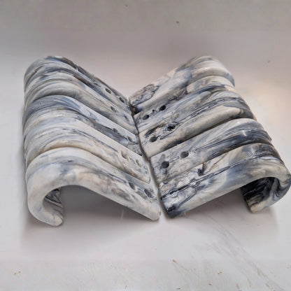Marble-patterned hooks on a white surface