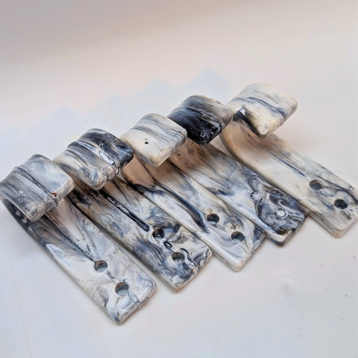 Marble-patterned metal brackets on a light background
