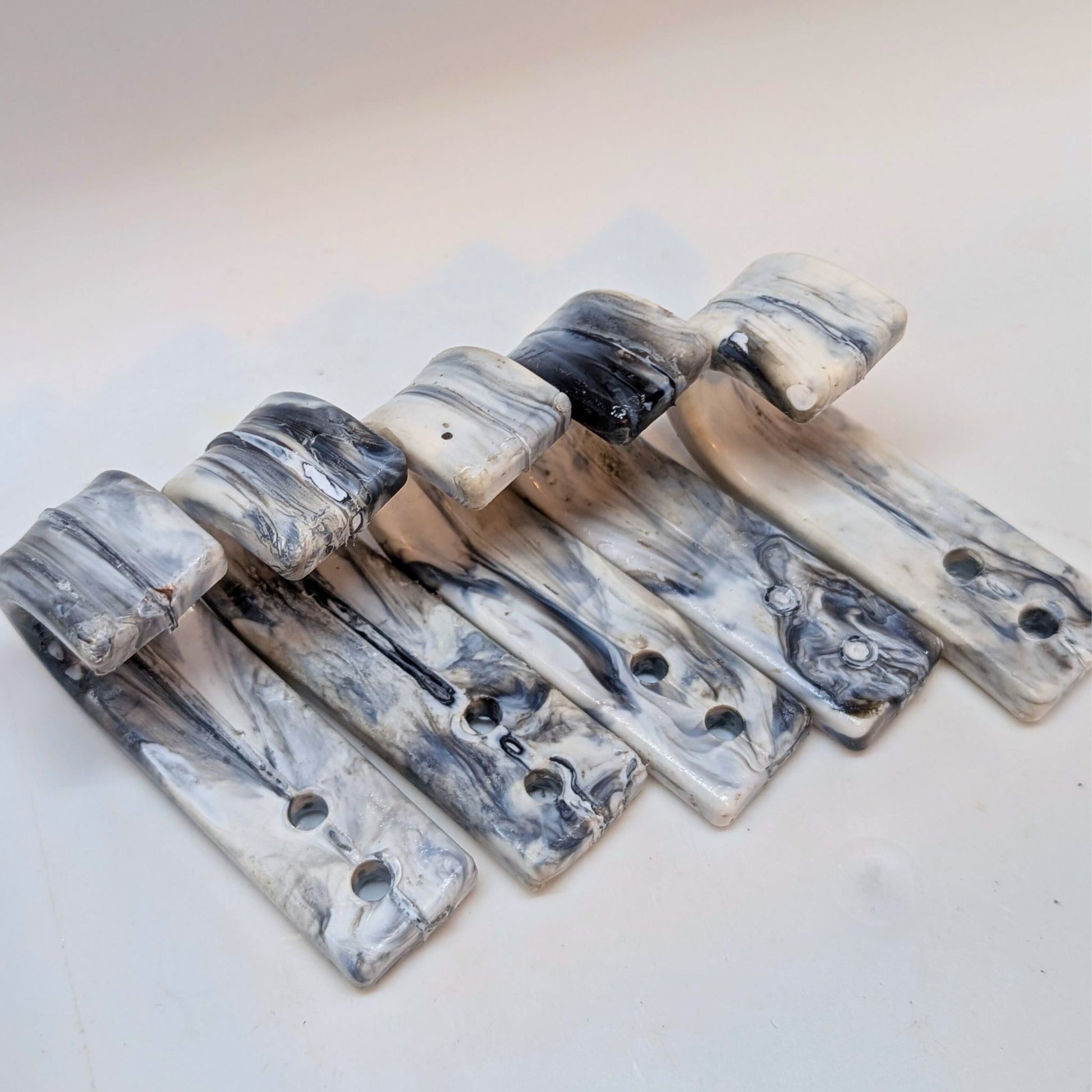 Marble-patterned metal brackets on a light background