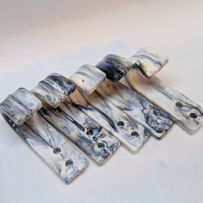 Marble-patterned metal brackets on a light background